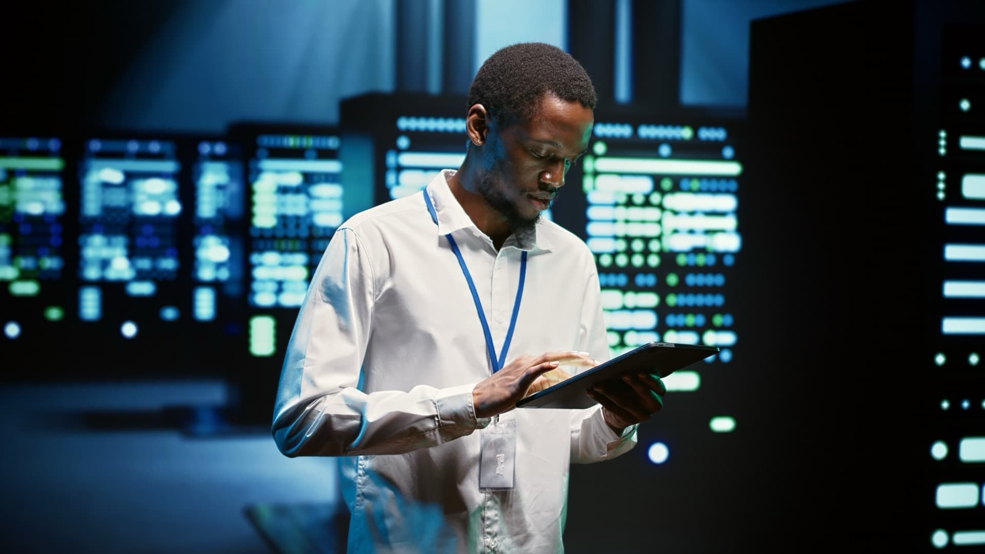 Technician walking through rows of server racks in a data centre